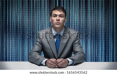Young specialist in business suit and tie sitting at desk. Digital technology for business. Man on abstract digital backdrop. Human resources in modern internet company. Headhunting and hr managment