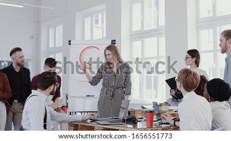 Young happy beautiful blonde CEO woman speaking to diverse employees at modern office meeting slow motion RED EPIC.