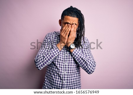 Young handsome african american afro man with dreadlocks wearing casual shirt rubbing eyes for fatigue and headache, sleepy and tired expression. Vision problem