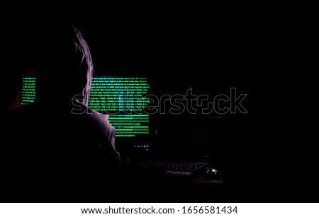 Women hacker breaks into government data servers and Infects Their System with a Virus at his hideout place has dark atmosphere, Lady hooded using laptop on binary code background , Malware conce