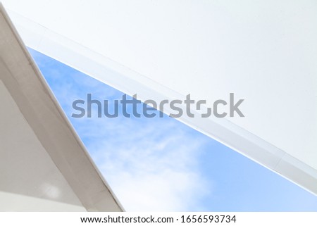 White sail shaped awnings are under bright blue sky, abstract background photo