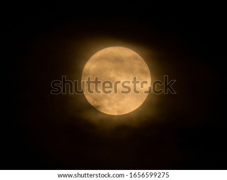 Full moon behind the clouds