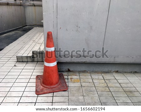 Red traffic cone on dirty background