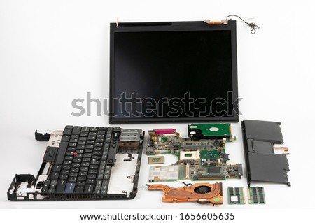 Disassembled laptop, basic components of notebook, screen, keyboard, processor, motherboard, internal  hard disk drive, CPU fan.