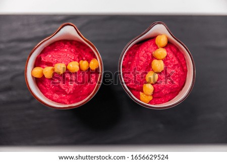 Pink Hummus with beet on yellow bright plate. Vegan healthy eating. top view, flat lay.