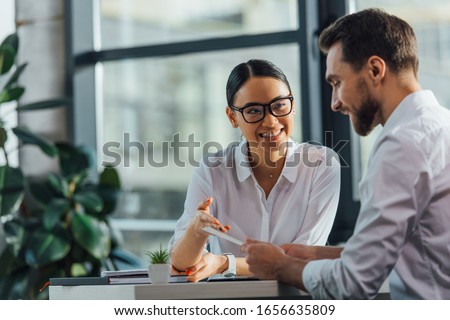 female asian translator working working with smiling businesswoman