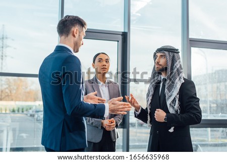 multicultural businesspeople discussing work on meeting with translator in modern office