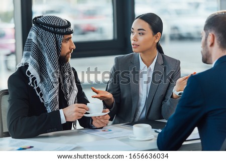 multiethnic business partners on meeting with translator in office