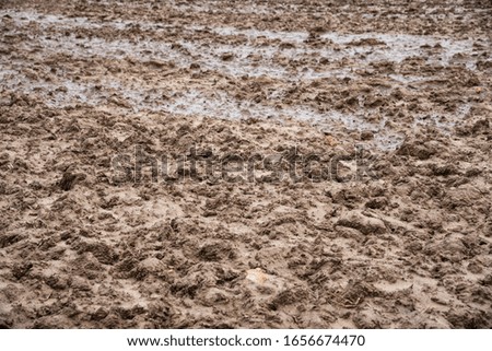 Plowed field after rain. Muddy wet terrain. Cultivated farm land background. Agriculture concept.