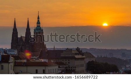 A beautiful view of Prague at sunrise on a misty morning timelapse. Prague Castle and St. Vitus Cathedral on the left and a golden rising sun in the background. Close up view