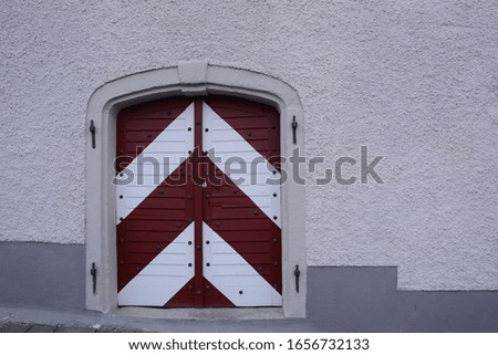 unique wood door with red and white colour taken at salzburg city in austria