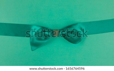 green silk gift bow ribbon isolated on green background