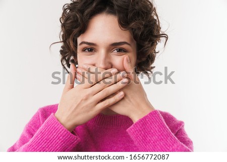 Image of joyful beautiful woman smiling and covering her mouth isolated over white background