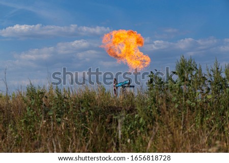 Oil pumpjack and gas torch on oil production