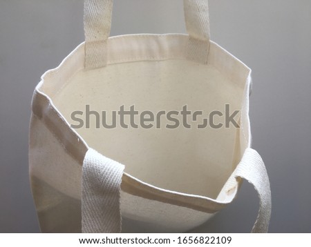 Plain blank canvas bag hanging on wall seeing inside of bag with space for logo, brand name, runaround or wraparound text 
