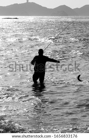 fisherman with his rod and a fish