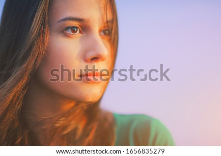 Beautiful young woman relaxing and enjoying sun at sunset. Beauty sunshine girl side profile portrait. Pretty happy lady enjoying summer outdoors. Positive emotion life success mind peace concept Royalty-Free Stock Photo #1656835279