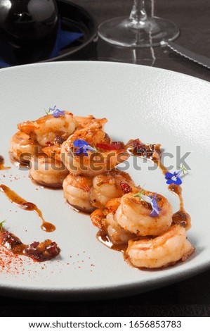 tiger prawns in sauce decorated with small flowers