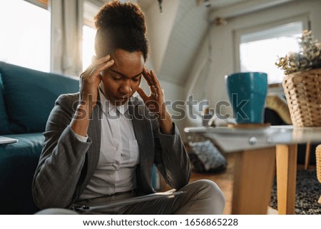 African American businesswoman having a headache and feeling tired while working at home. 