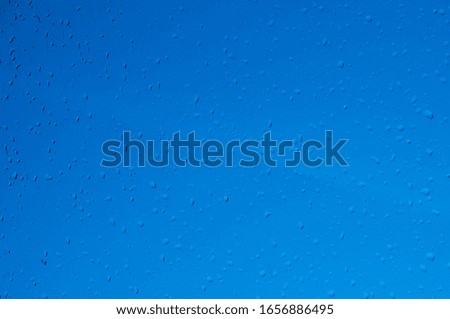 Drops of water on the glass. Rain. Blue background