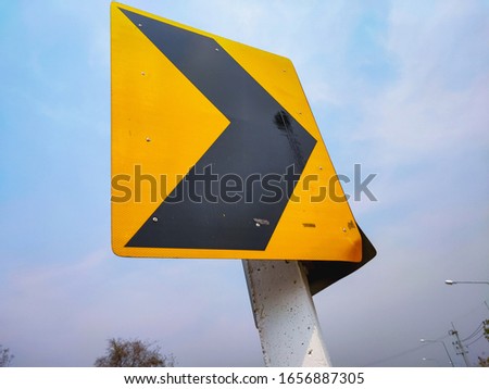 Traffic signs with an arrow pointing to the right are telling you that the road ahead is curving to the right.