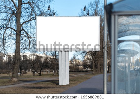A billboard standing near a stop. advertising large metalwork on one metal leg. With a white space for posters Advertising canvas copy space on beautiful weather park background