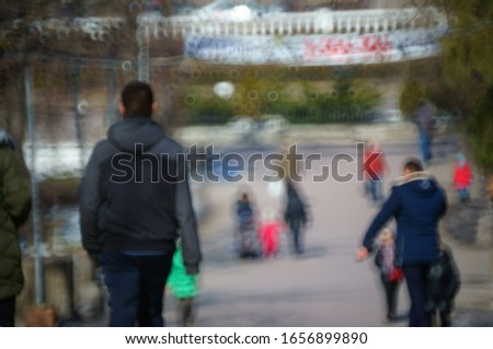 Blurred background. People walk in the recreation Park. City life. The movement of the crowd. Silhouettes of people. Family holiday.