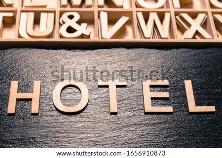 word "hotel" in wooden letters, top view