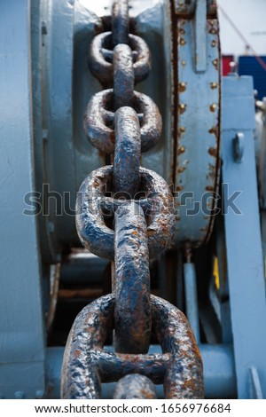 Rusty anchor chain on a winch on a ship.