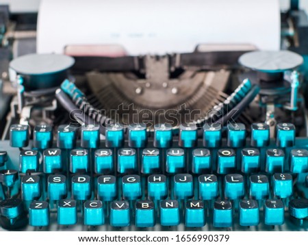 Old vintage typewriter, retro machine with white sheet of paper and typed text.