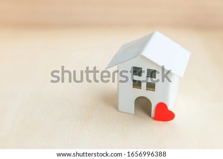 Miniature toy model house with red heart on wooden backdrop. Eco Village, abstract environmental background. Real estate mortgage property insurance sweet dream home ecology concept