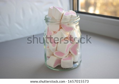 Detail of glass jar with white and pink marshmallows