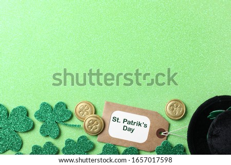 Clover leaves and tag with phrase St. Patrick's Day on light green background, flat lay. Space for text