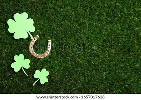 Flat lay composition with horseshoe on grass, space for text. St. Patrick's Day celebration