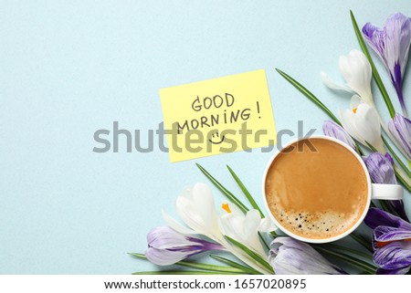 Delicious coffee, flowers and card with GOOD MORNING wish on light background, flat lay. Space for text