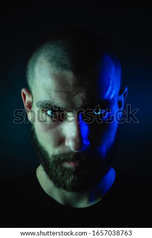 Portrait of a werewolf guy, close-up of a face with a scar on his face and a glowing eye.