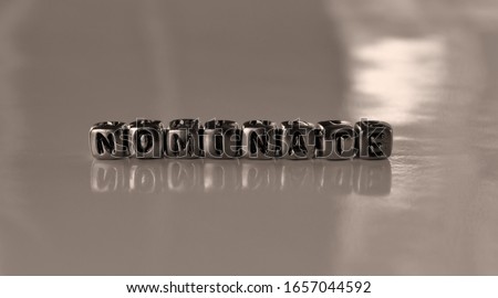 Nominate -  word from metal blocks - concept sepia tone photo on shine background
