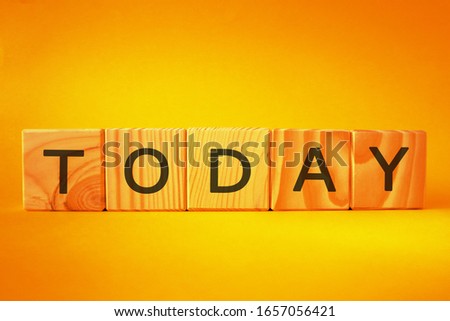 TODAY word made of wooden cubes on a yellow background