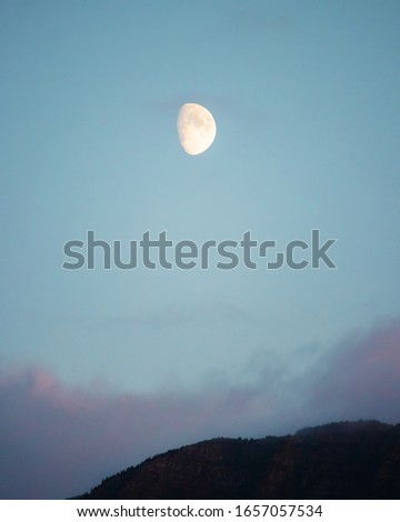 Moon cresting over the hills after sunset