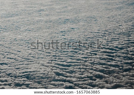 Sky cloudy overcast. Clouds texture background. View on blue clouds from above. View from airplane. Layer of clouds top view.