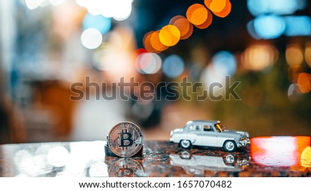 Silver bitcoin and Moskvich 401 on the table, glowing background