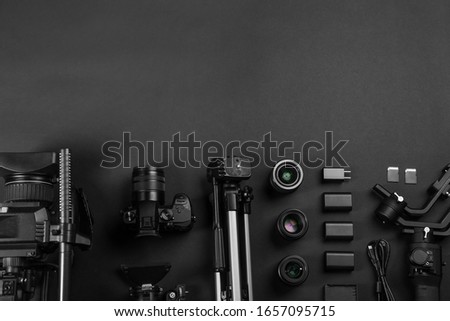 Flat lay composition with video camera and other equipment on black background. Space for text