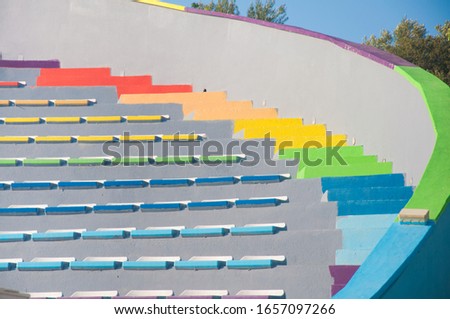 Different color empty plastic chairs an outdoor auditorium on summer sunny day. Fragment