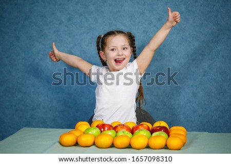 Little girl in white T-shirt love fruit