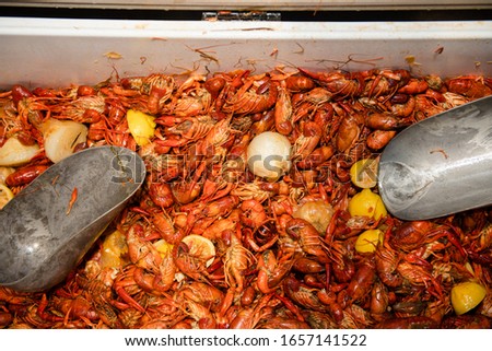 overhead closeup view of a large quantity of cooked crawfish ready to eat at a crawfish boil party