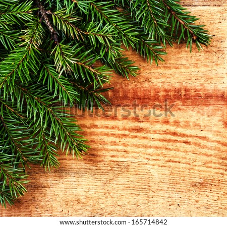 Christmas Fir Tree Branch on rustic  wood background with copy space for greeting text. Christmas Card with winter festive decoration