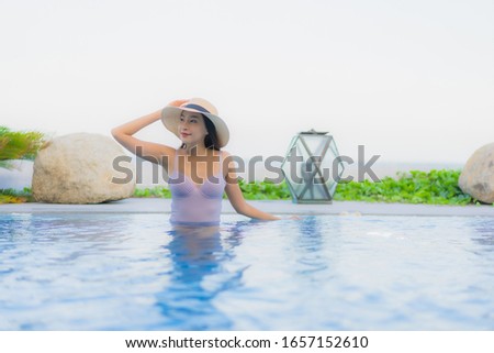 Portrait beautiful young asian woman happy smile relax around outdoor swimming pool in hotel resort for leisure vacation