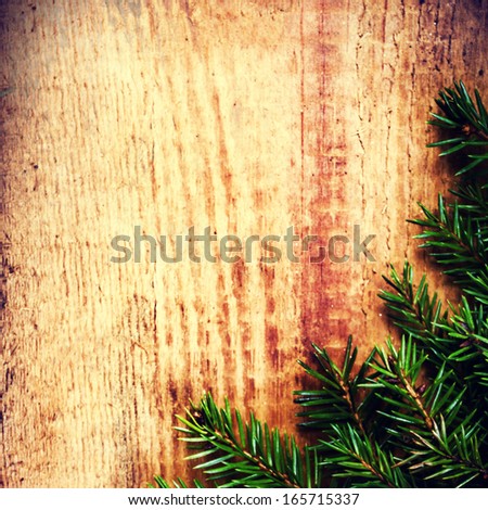 Tree Branch on wooden background with forest cone and copy space for greeting text. Christmas ornaments close up. Vintage Christmas Card.