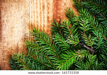 Christmas Fir Tree Branch on rustic  wooden board with copy space for text. Christmas Card with winter festive ornaments