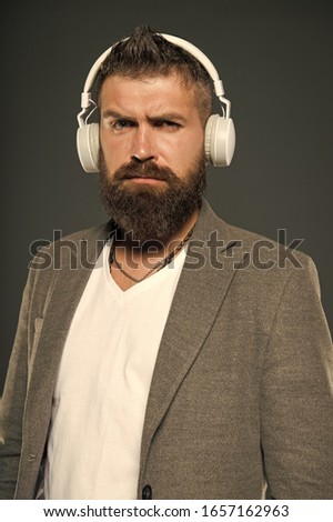 Lifestyle music fan. Man listening music wireless headphones. Hipster use headphones gadget. Inspiring song. Music library. Bearded guy enjoy music. Audio book. Application for listening books.